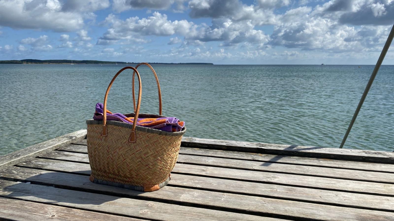 Strandtaske på Sydstrandens badebro i Kerteminde med havet og himlen i baggrunden. 